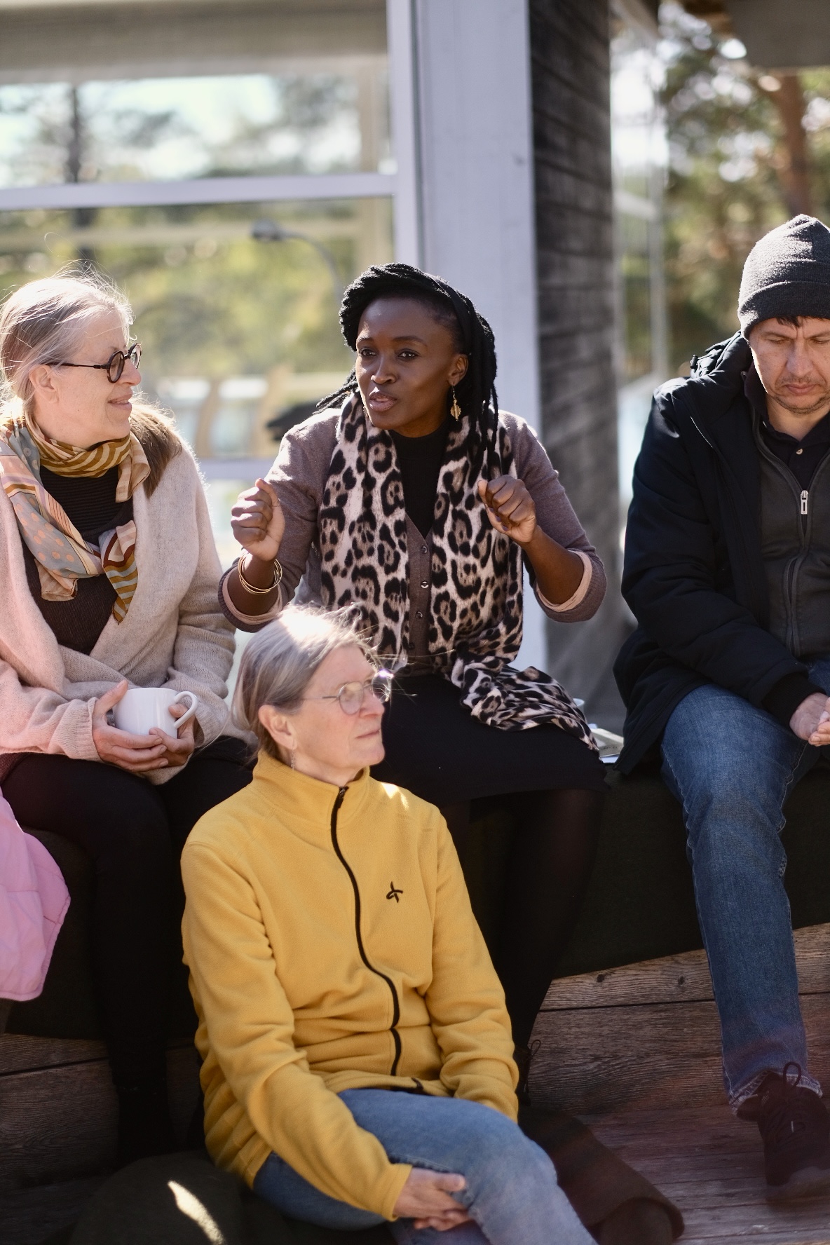 Participants gathered on a wooden porch in the afternoon sun